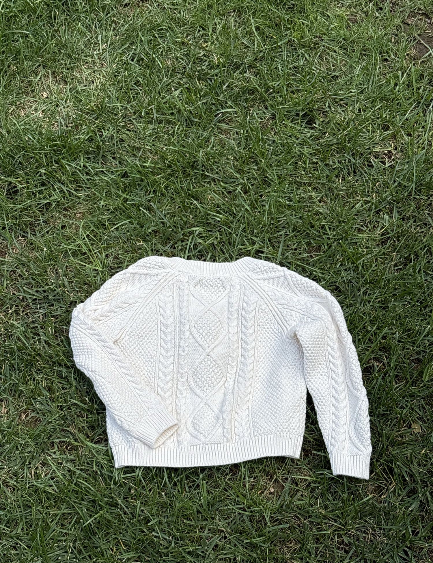 Pre-loved Amazon Essentials sofia grainge cream cable-knit cardigan, kids size 4T, back view, laid flat on grass