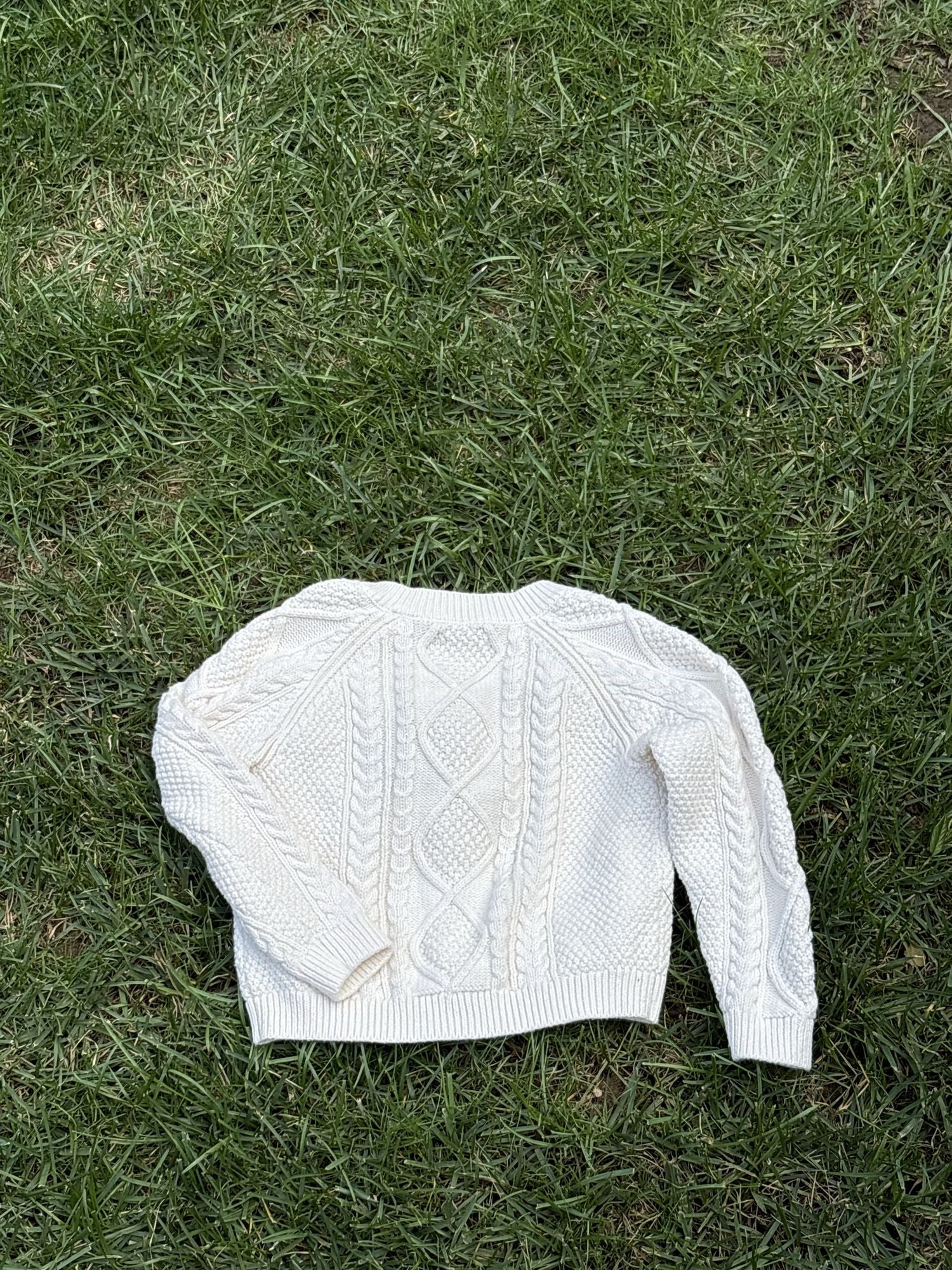 Pre-loved Amazon Essentials sofia grainge cream cable-knit cardigan, kids size 4T, back view, laid flat on grass