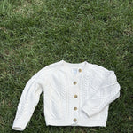 Pre-loved Amazon Essentials sofia grainge cream cable-knit cardigan, kids size 4T, front view, laid flat on grass