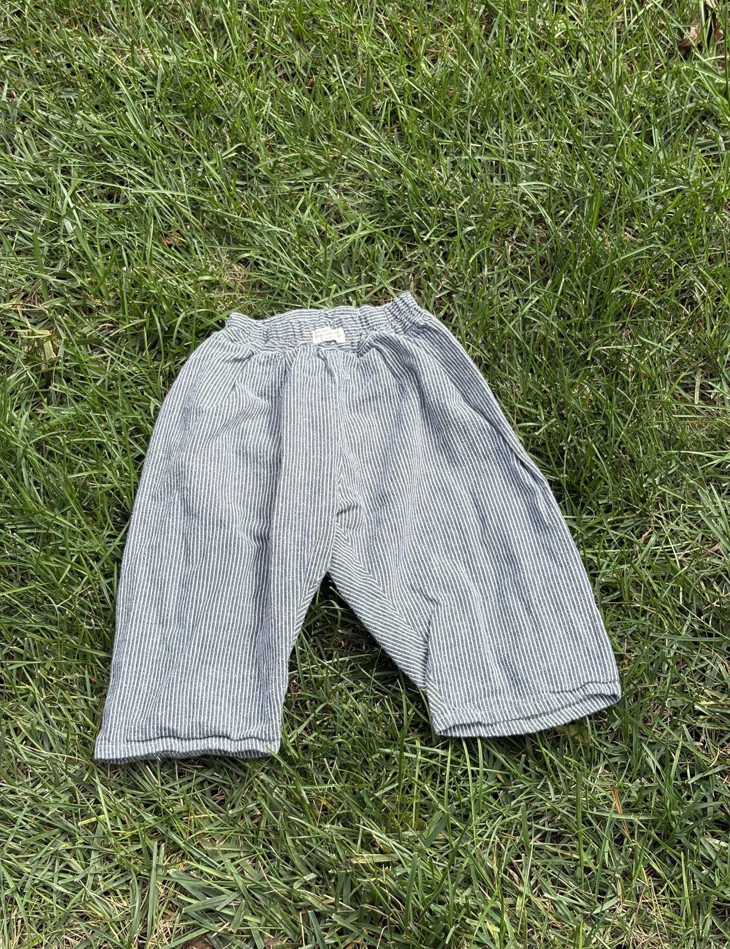 Pre-loved Aosta blue hickory stripe pull-on pants, kids size 2T, back view, laid flat on grass