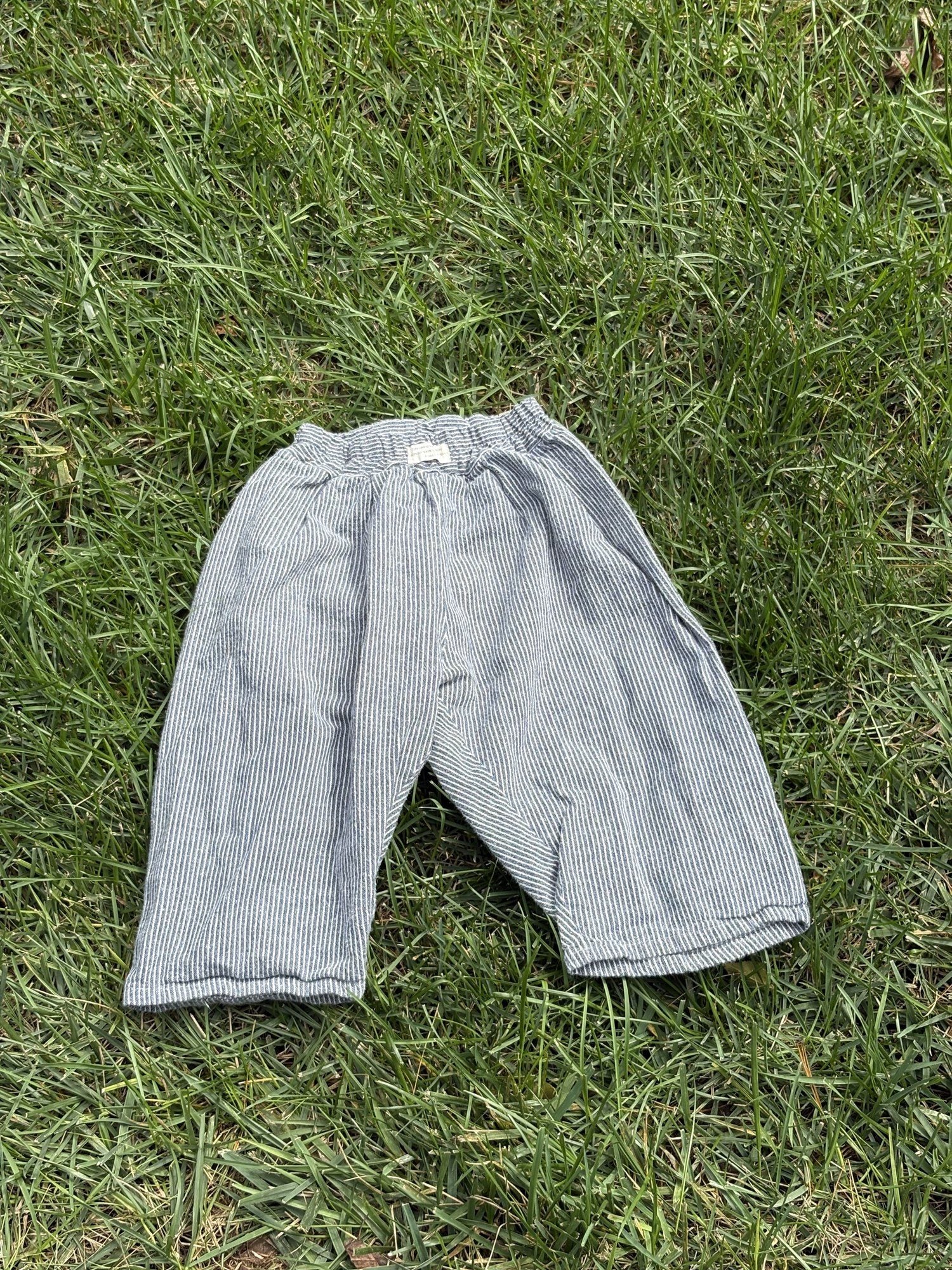 Pre-loved Aosta blue hickory stripe pull-on pants, kids size 2T, back view, laid flat on grass