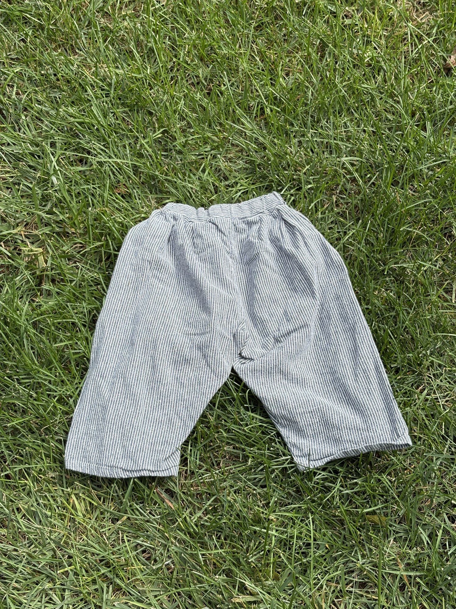 Pre-loved Aosta blue hickory stripe pull-on pants, kids size 2T, front view, laid flat on grass