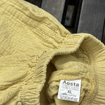 Pre-loved Aosta butter yellow cotton gauze pull-on pants, kids size 2T, brand and size label close-up