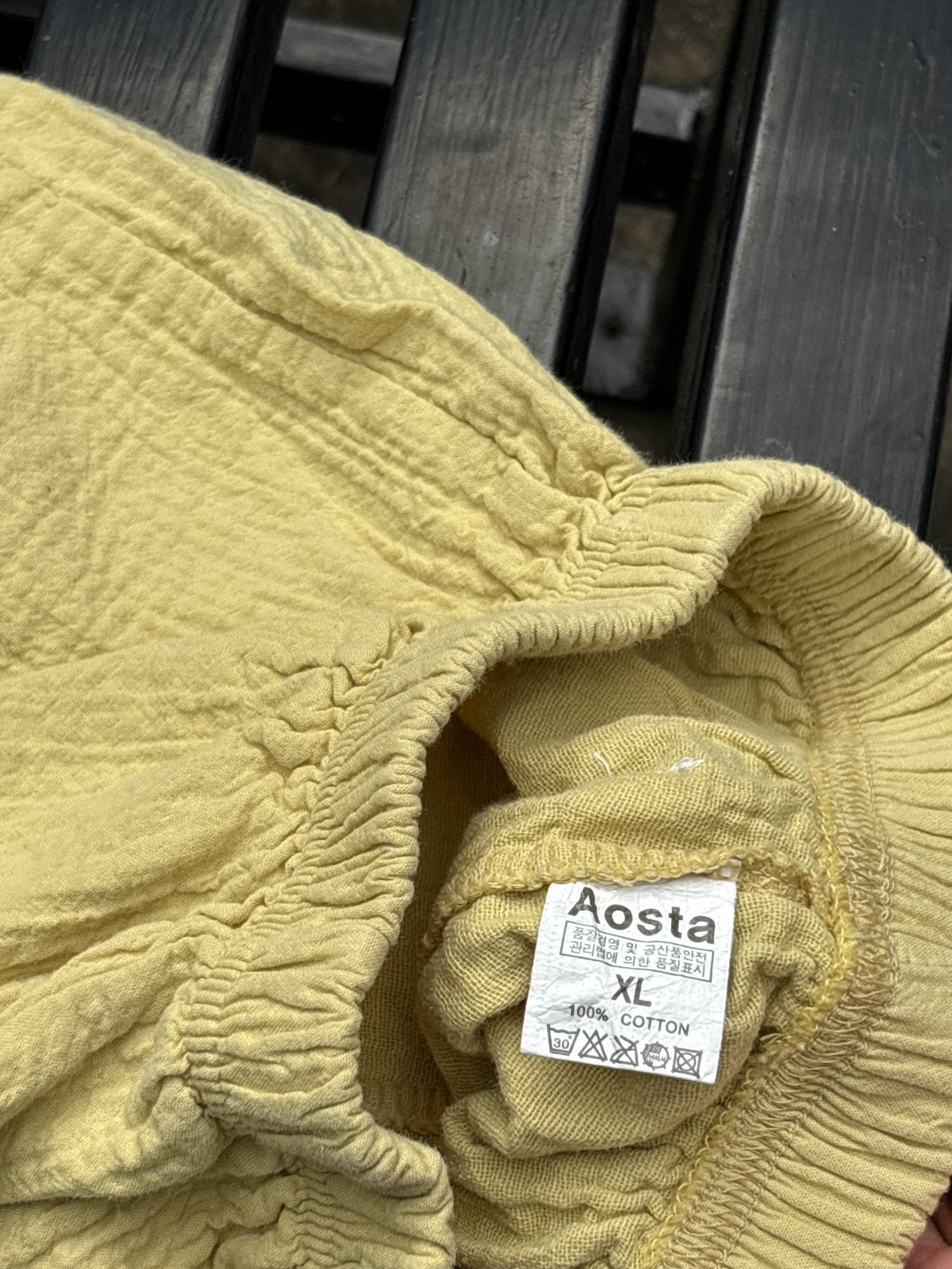 Pre-loved Aosta butter yellow cotton gauze pull-on pants, kids size 2T, brand and size label close-up