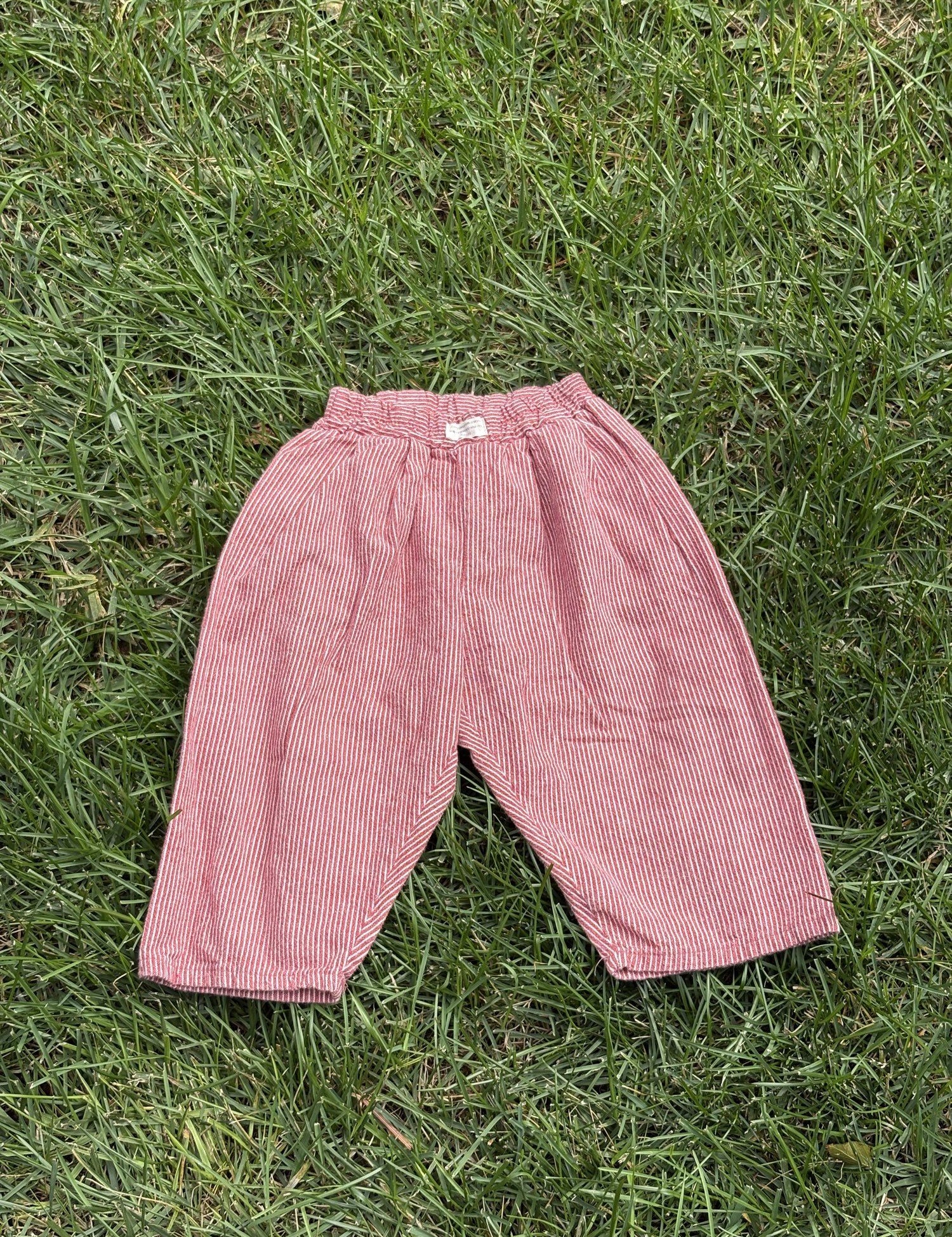 Pre-loved Aosta red hickory stripe pull-on pants, kids size 2T, back view, laid flat on grass