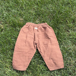 Pre-loved Aosta rust cotton gauze pull-on pants, kids size 2T, back view, laid flat on grass