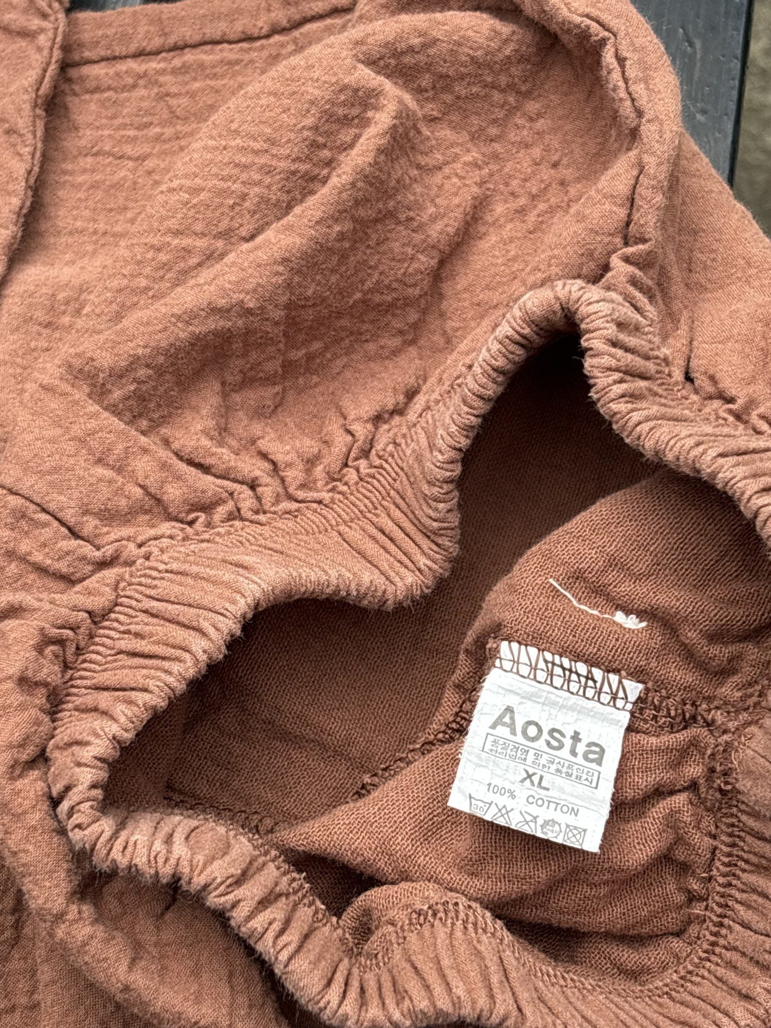Pre-loved Aosta rust cotton gauze pull-on pants, kids size 2T, brand and size label close-up