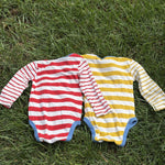 Pre-loved Boden red and yellow striped bodysuit 2-pack, kids size 12M, back view, laid flat on grass