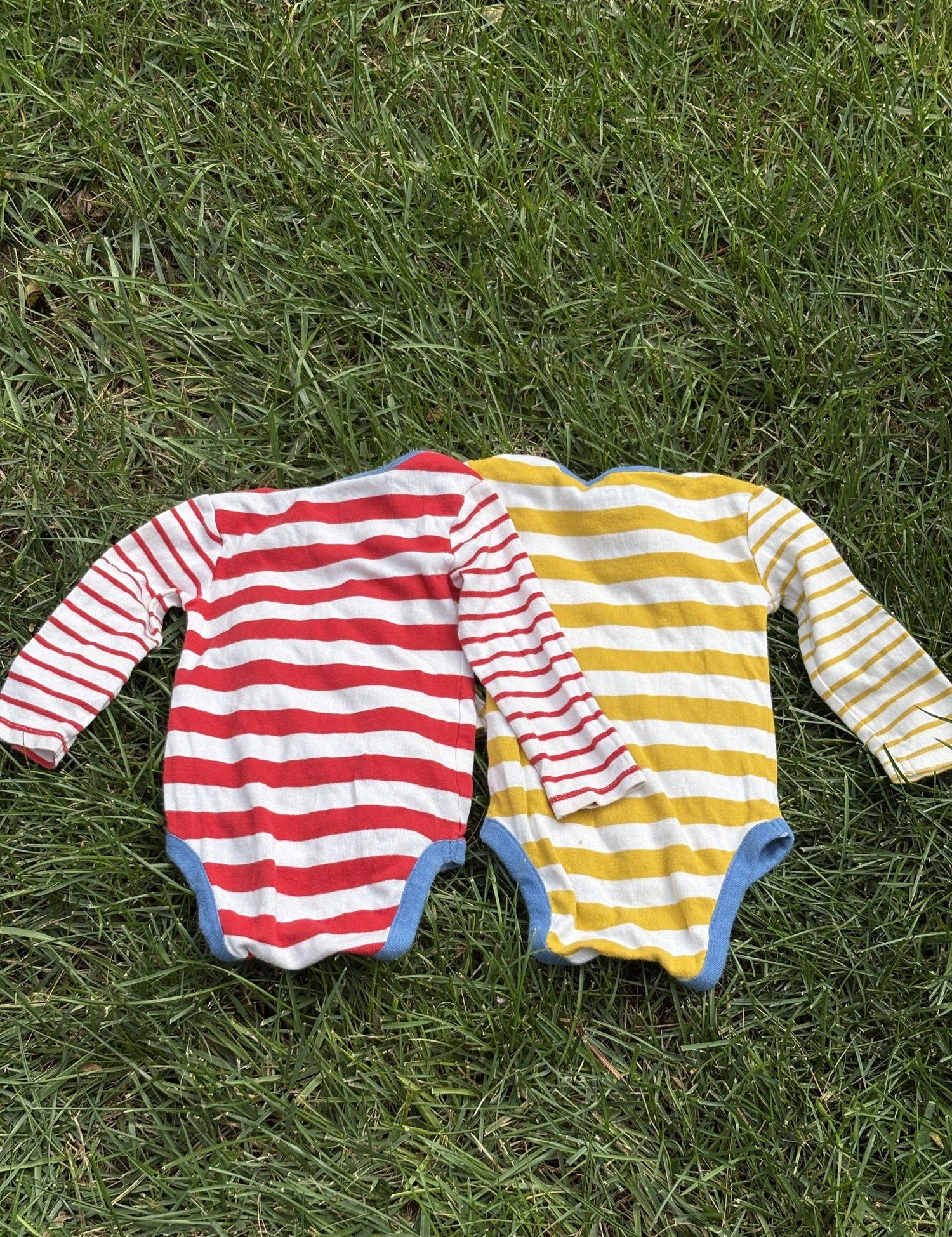 Pre-loved Boden red and yellow striped bodysuit 2-pack, kids size 12M, back view, laid flat on grass