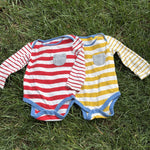 Pre-loved Boden red and yellow striped bodysuit 2-pack, kids size 12M, front view, laid flat on grass