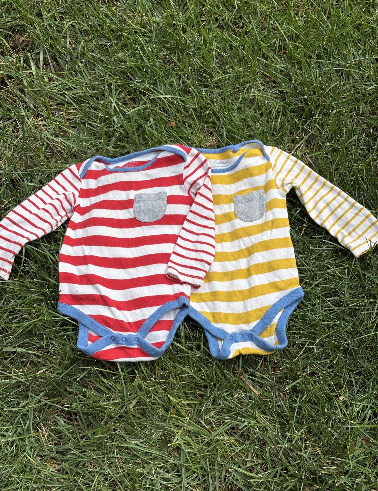 Pre-loved Boden red and yellow striped bodysuit 2-pack, kids size 12M, front view, laid flat on grass