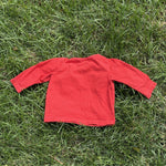 Pre-loved Boden red train graphic long-sleeve tee, kids size 6-12M, back view, laid flat on grass