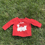 Pre-loved Boden red train graphic long-sleeve tee, kids size 6-12M, front view, laid flat on grass