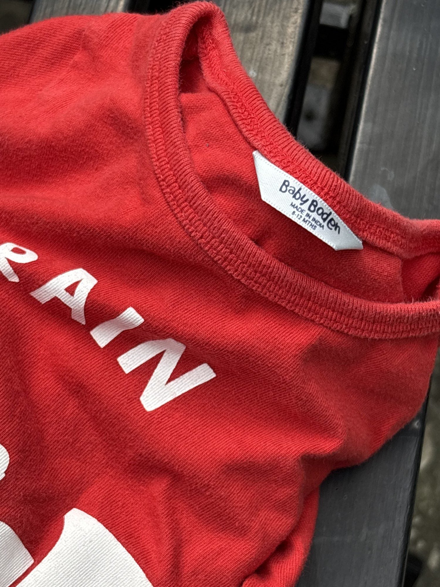 Pre-loved Boden red train graphic long-sleeve tee, kids size 6-12M, brand and size label close-up