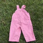 Pre-loved Carhartt pink canvas bib overalls, kids size 12M, front view, laid flat on grass