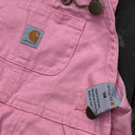 Pre-loved Carhartt pink canvas bib overalls, kids size 12M, brand and size label close-up