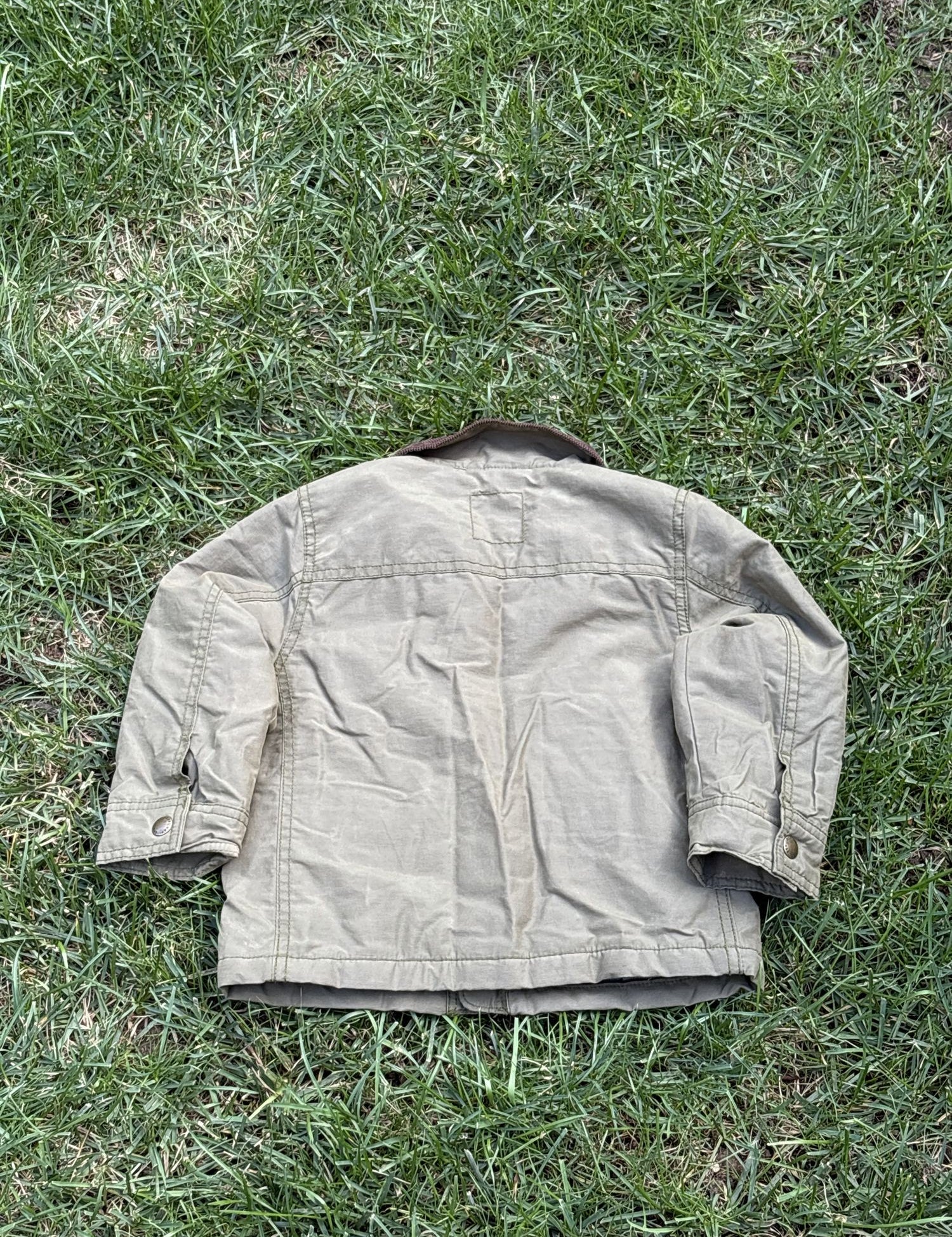 Pre-loved Gap khaki field jacket with corduroy collar, kids size 3T, back view, laid flat on grass
