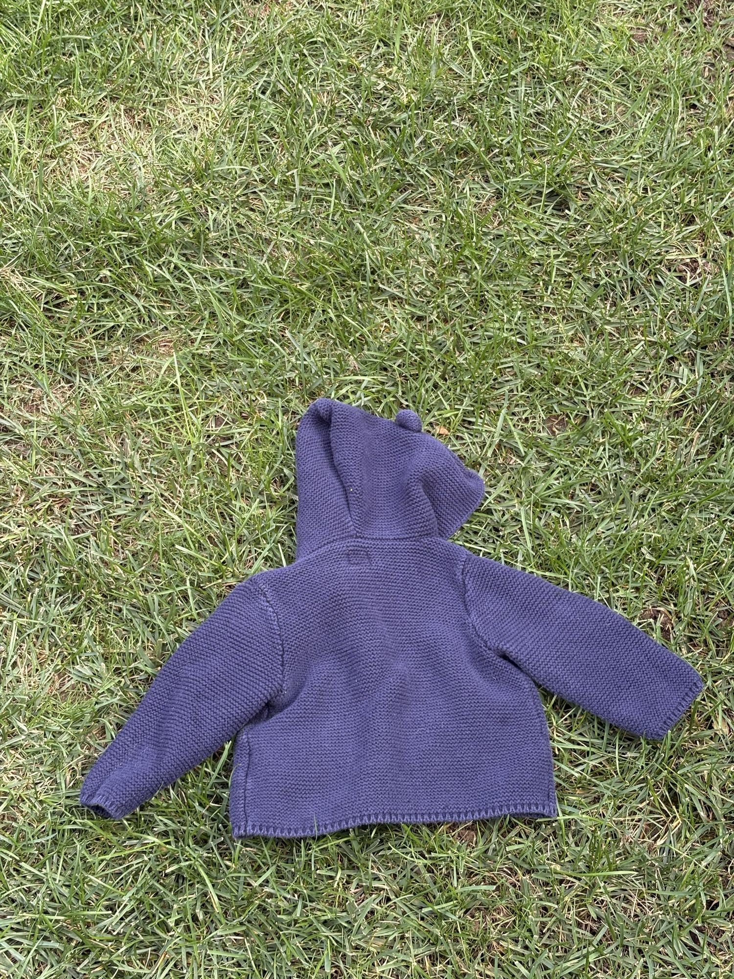 Pre-loved Gap navy bear-ear hooded knit cardigan, kids size 6-12M, back view, laid flat on grass