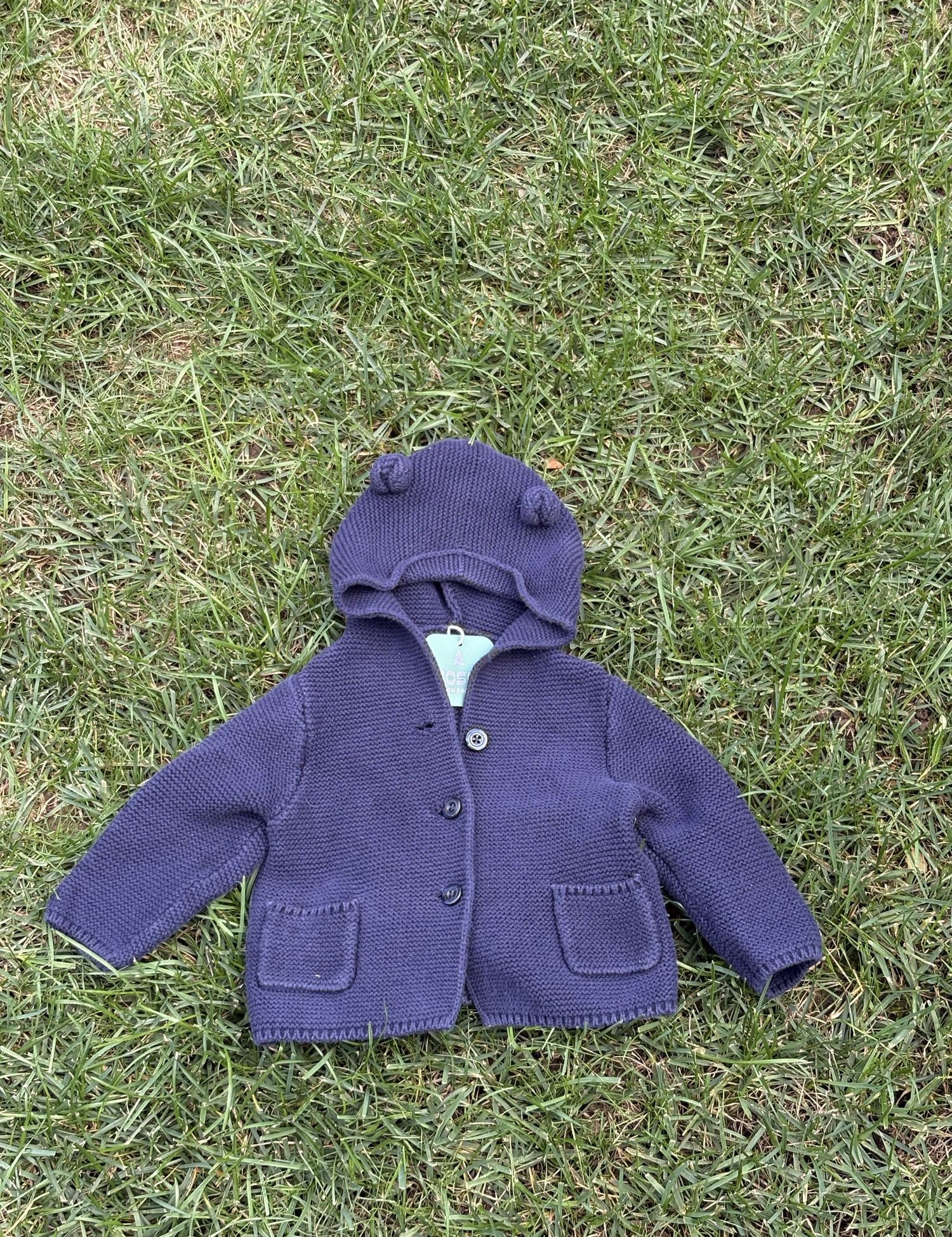 Pre-loved Gap navy bear-ear hooded knit cardigan, kids size 6-12M, front view, laid flat on grass