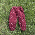 Pre-loved H&M burgundy floral corduroy pull-on pants, kids size 3T, back view, laid flat on grass