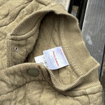 Pre-loved Hanna Andersson khaki quilted snap-front jacket, kids size 6-12M, brand and size label close-up