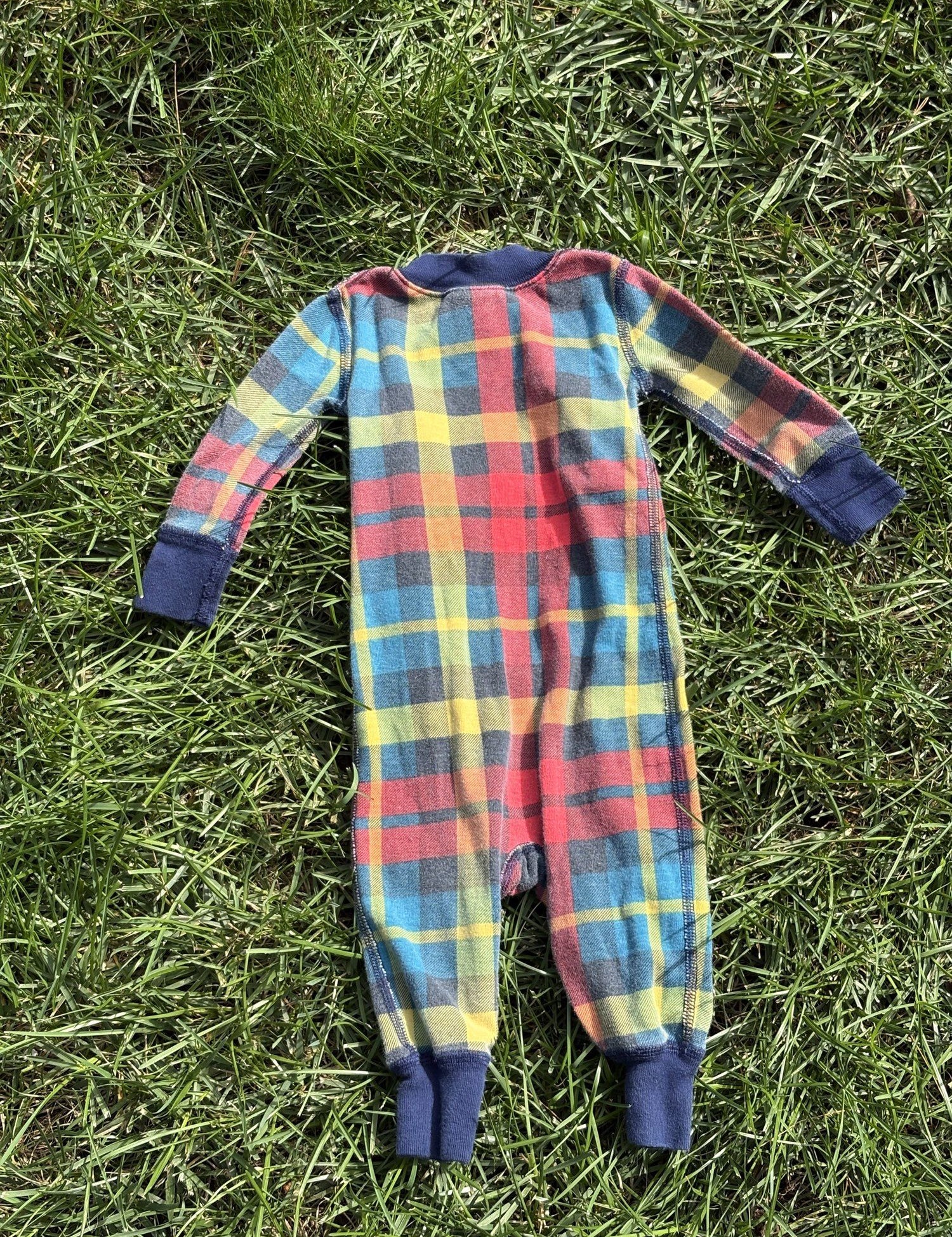 Pre-loved Hanna Andersson plaid organic cotton zip sleeper, kids size 6-12M, back view, laid flat on grass
