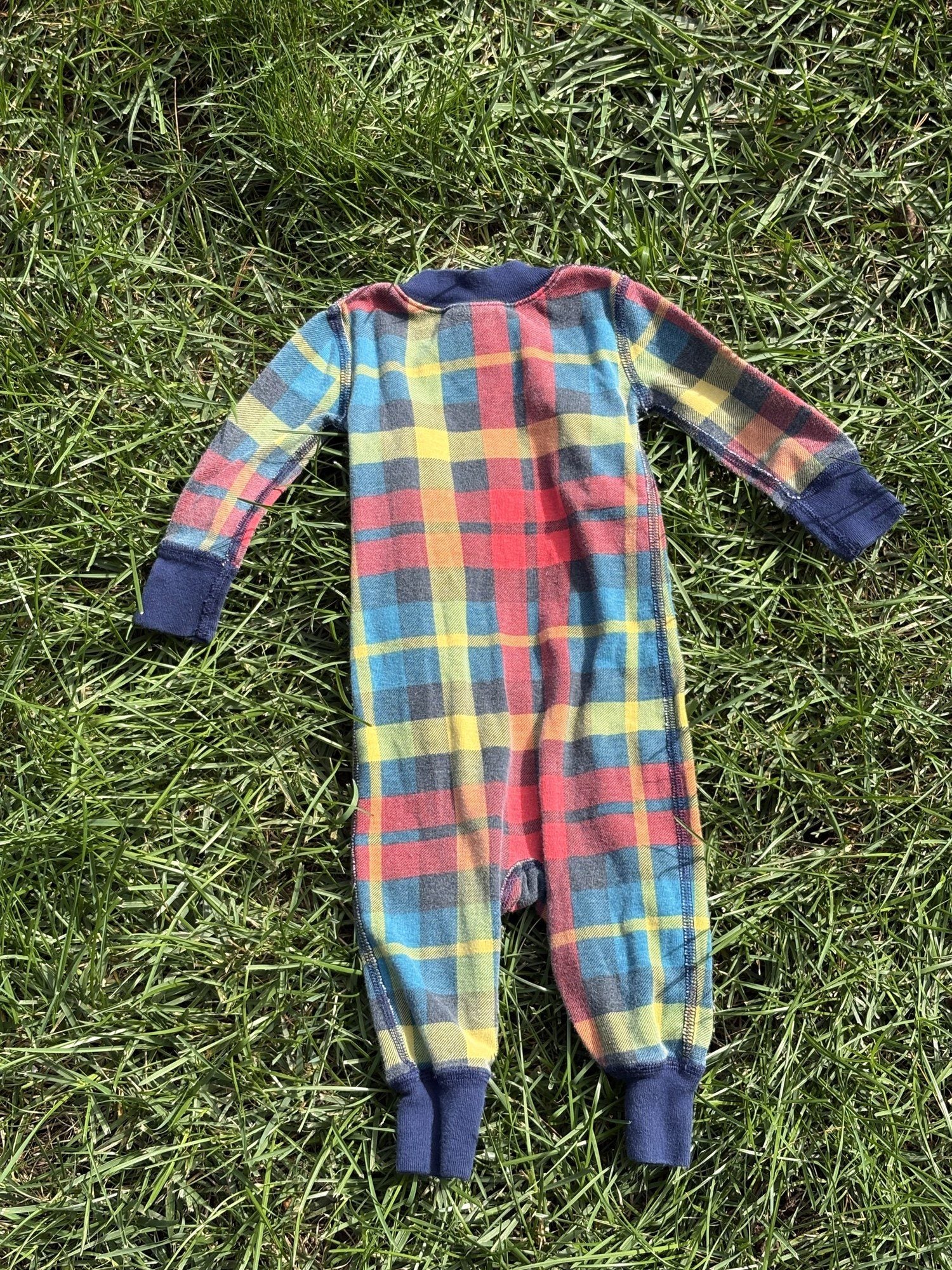 Pre-loved Hanna Andersson plaid organic cotton zip sleeper, kids size 6-12M, back view, laid flat on grass
