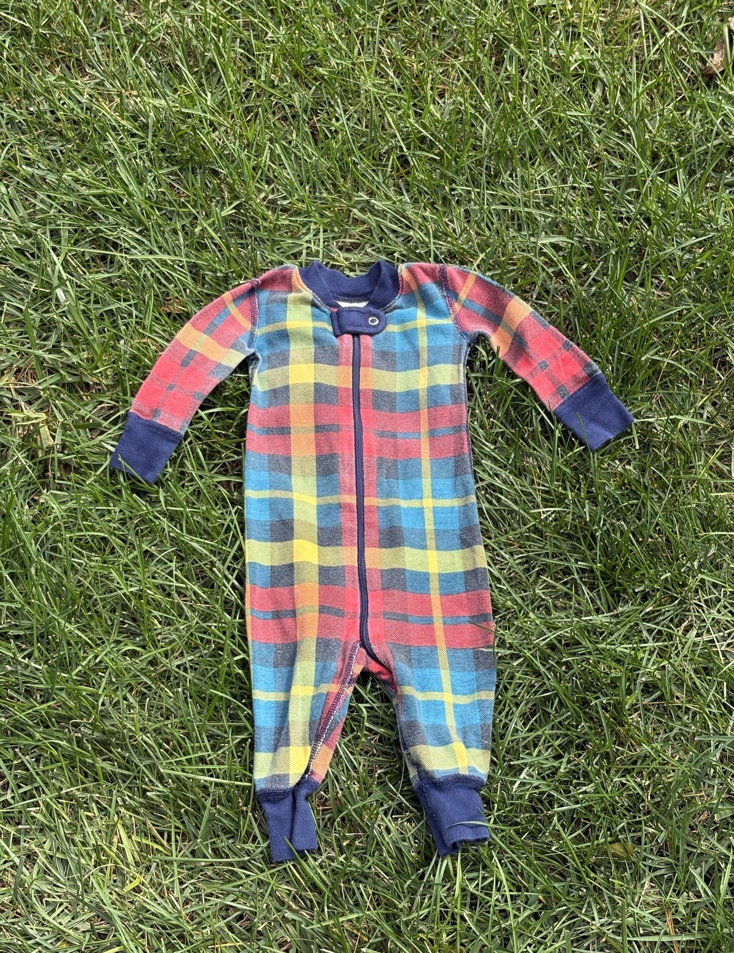 Pre-loved Hanna Andersson plaid organic cotton zip sleeper, kids size 6-12M, front view, laid flat on grass