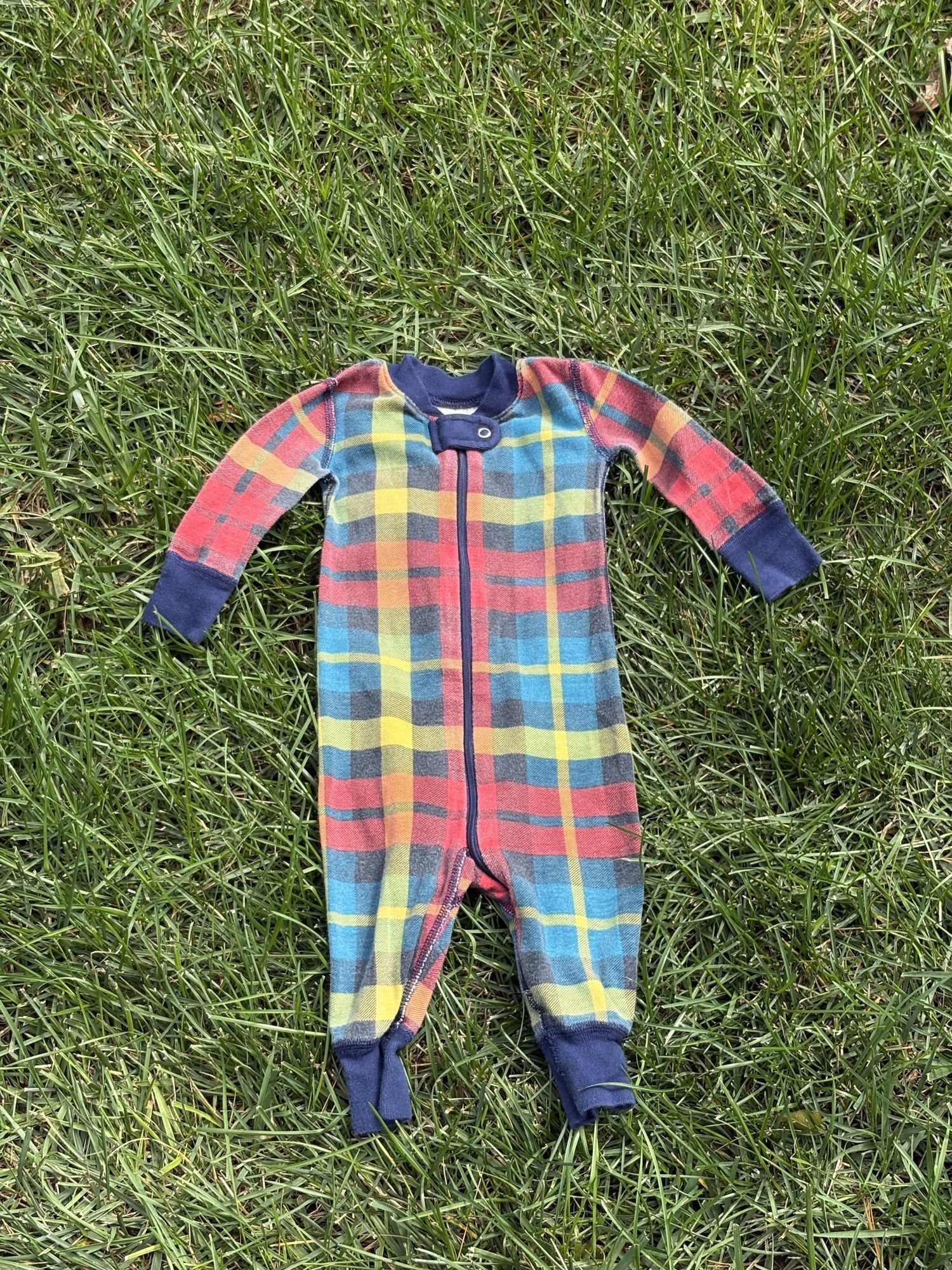 Pre-loved Hanna Andersson plaid organic cotton zip sleeper, kids size 6-12M, front view, laid flat on grass