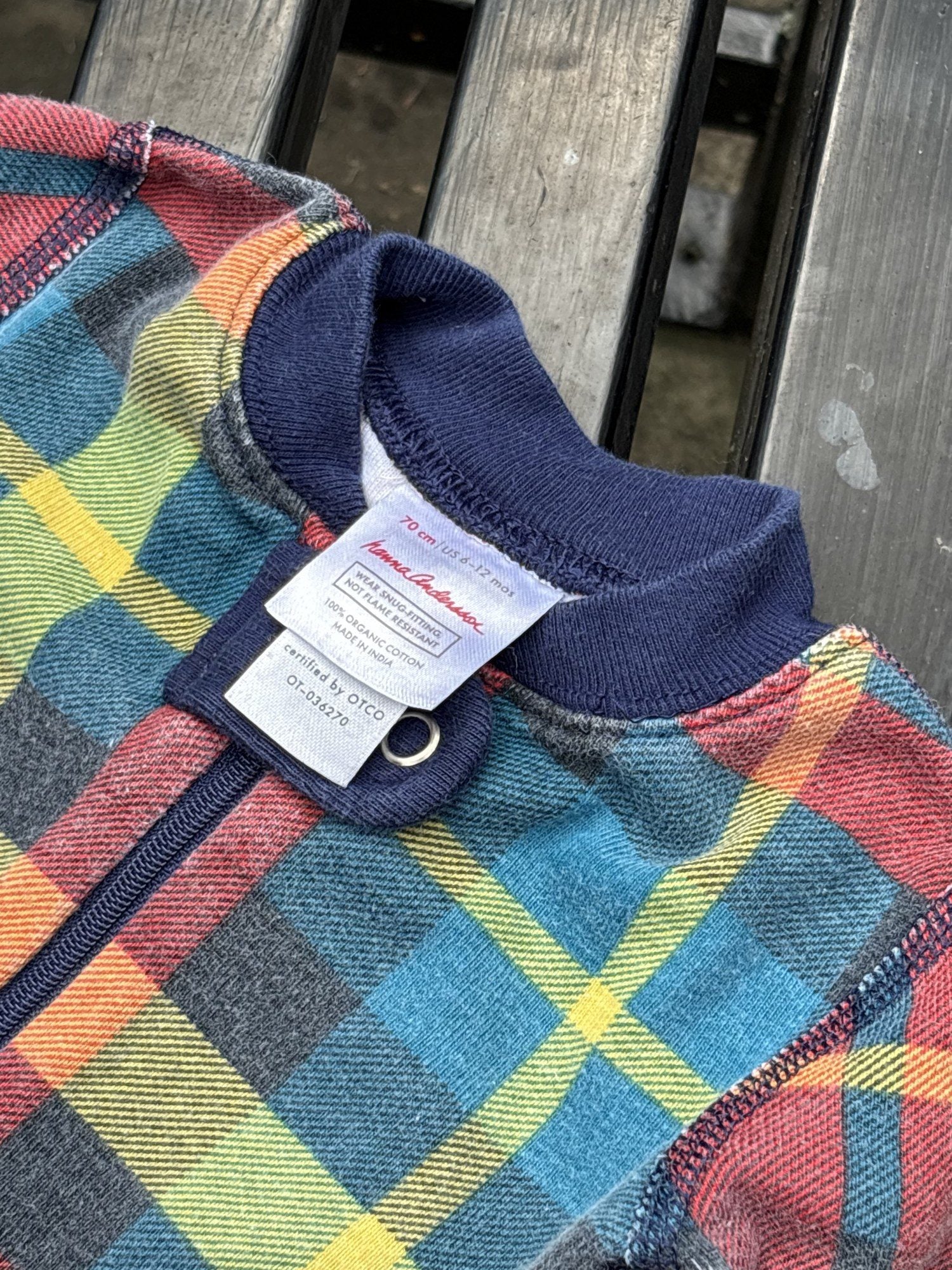 Pre-loved Hanna Andersson plaid organic cotton zip sleeper, kids size 6-12M, brand and size label close-up