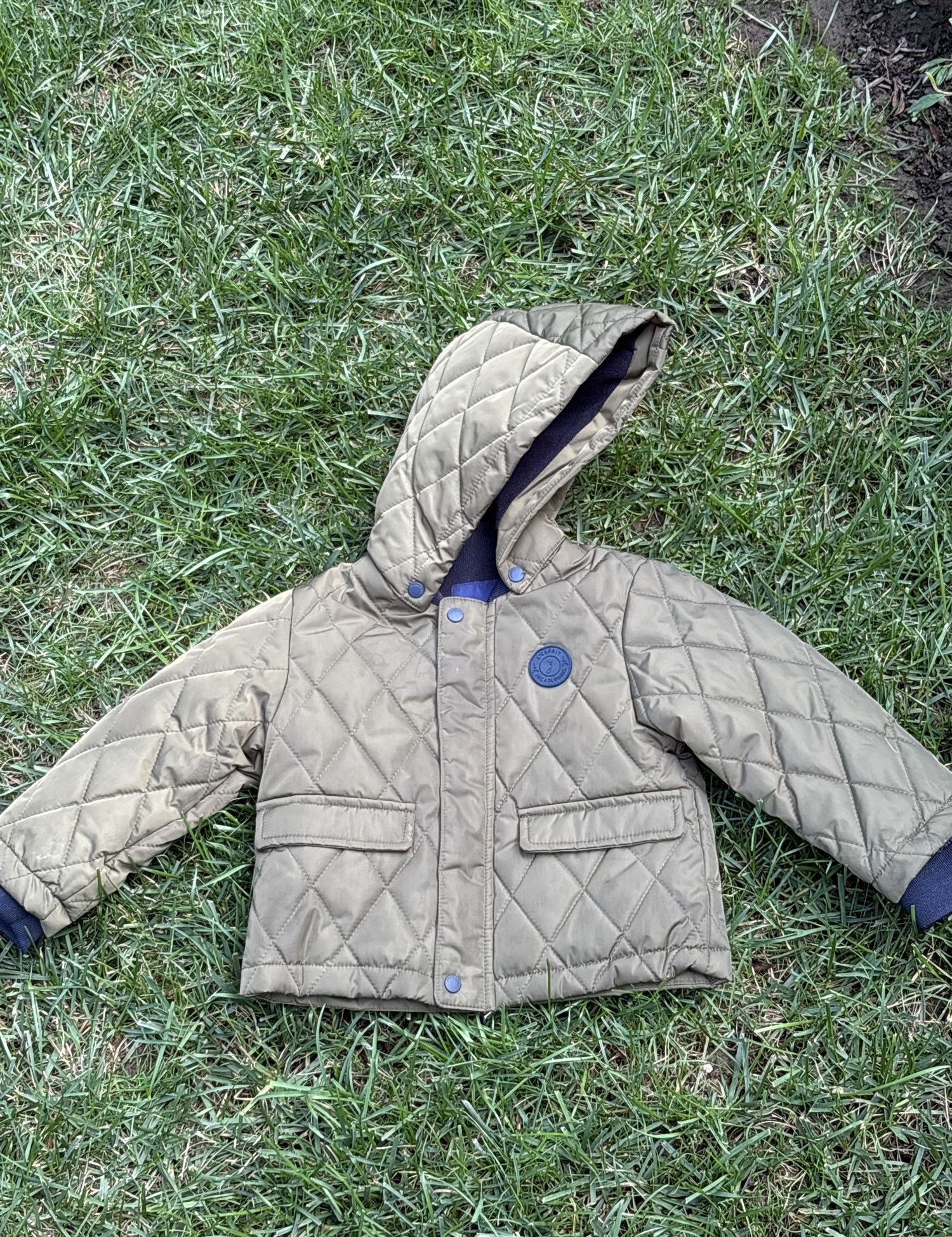 Pre-loved Jacadi olive quilted hooded jacket, kids size 18M, front view, laid flat on grass