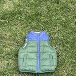 Pre-loved Janie and Jack green and blue colorblock puffer vest, kids size 18-24M, front view, laid flat on grass