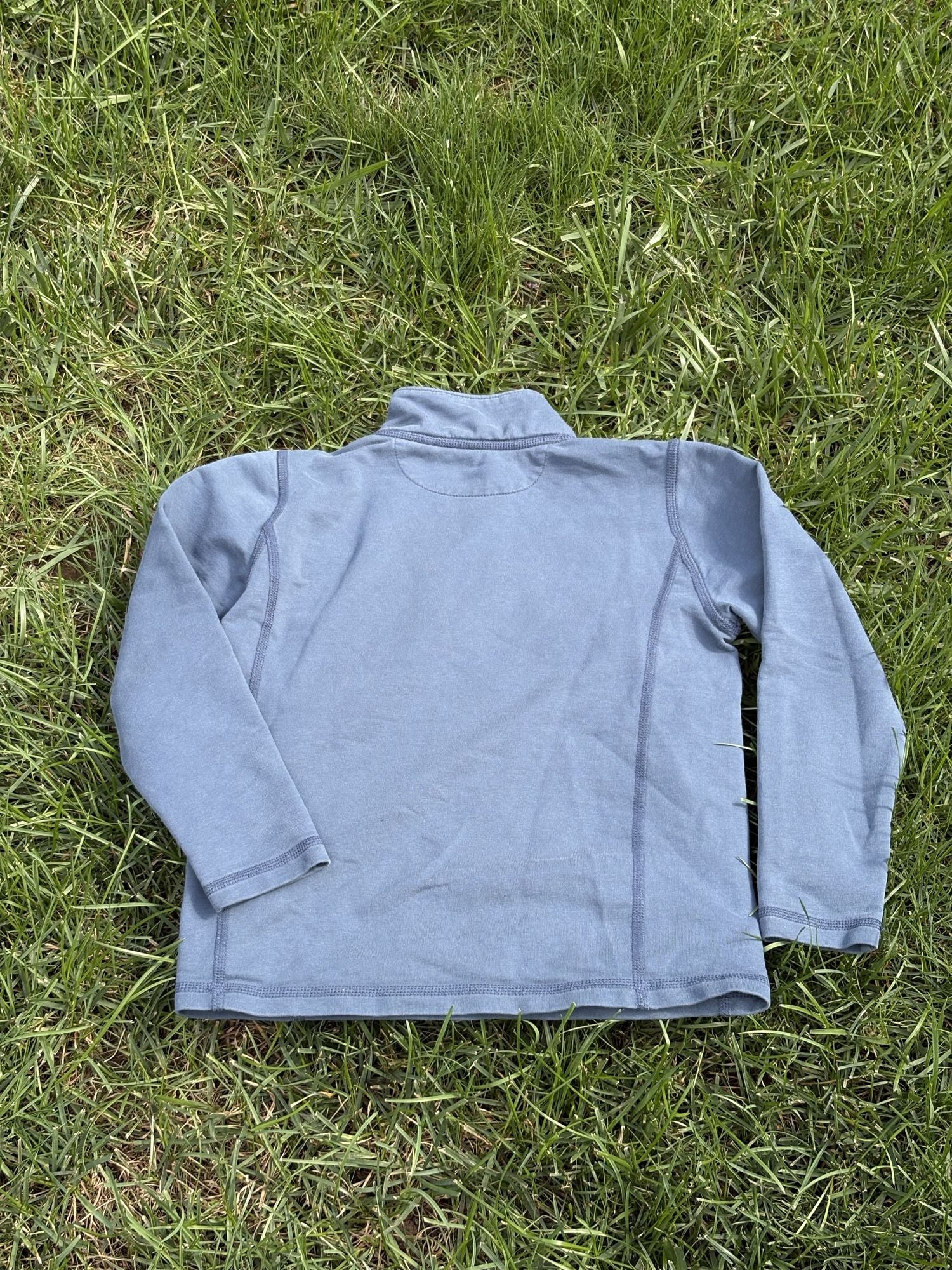 Pre-loved J.Crew blue performance quarter-zip pullover, kids size 6/7, back view, laid flat on grass