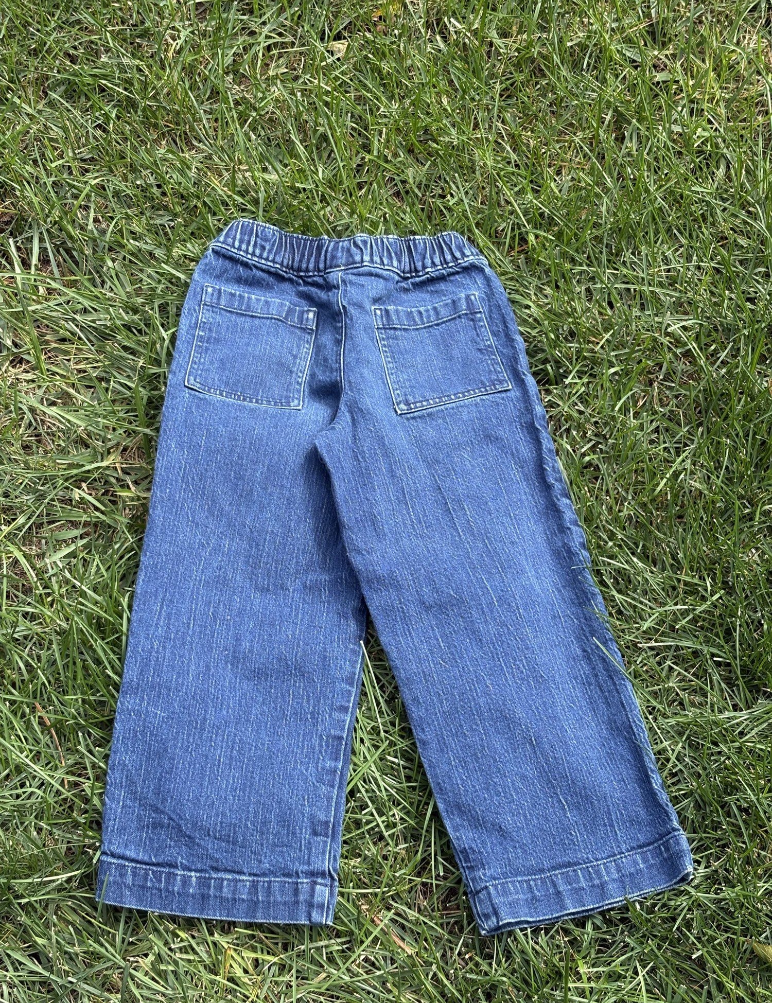 Pre-loved J.Crew wide-leg pull-on jeans, kids size 8, back view, laid flat on grass