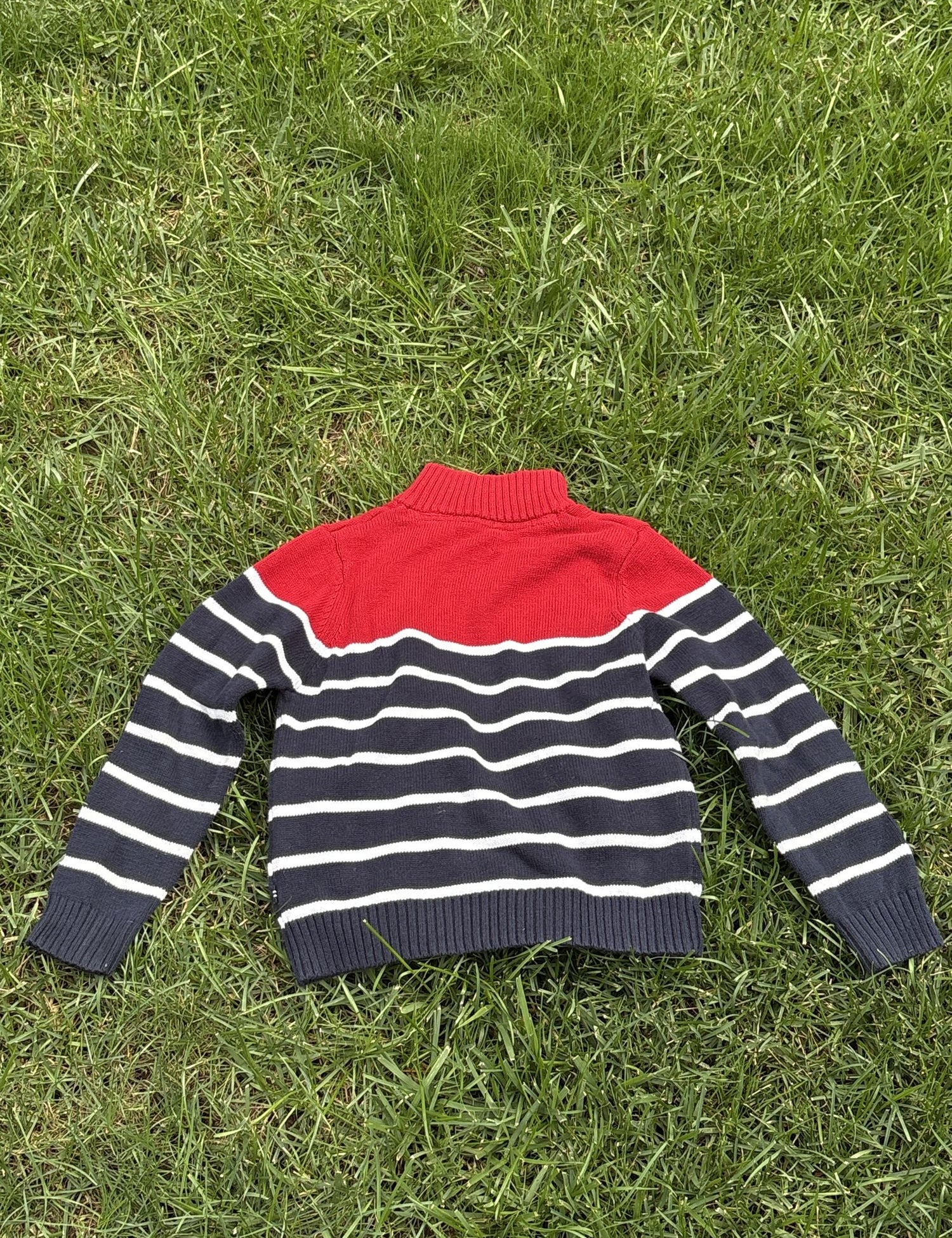 Pre-loved Nautica red and navy striped quarter-zip sweater, kids size 6, back view, laid flat on grass