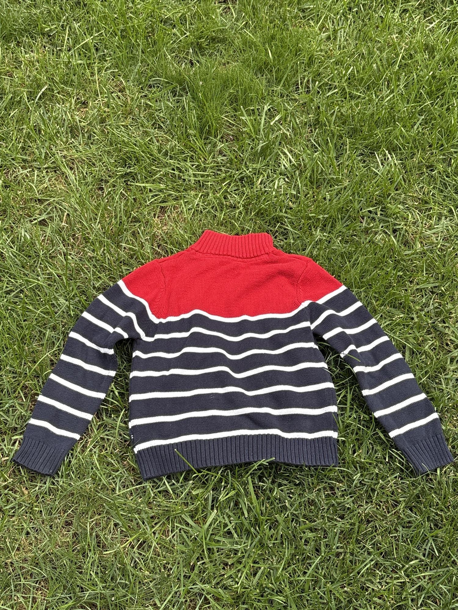 Pre-loved Nautica red and navy striped quarter-zip sweater, kids size 6, back view, laid flat on grass