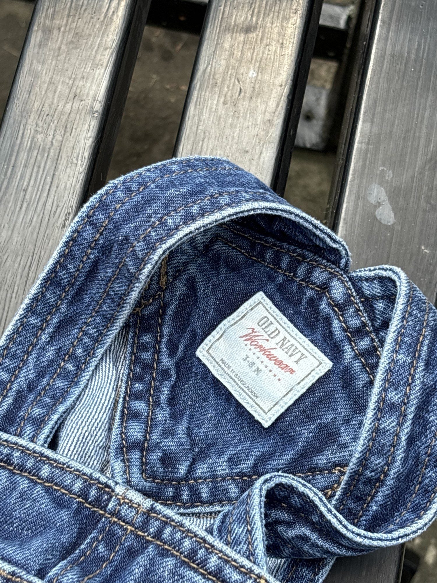 Pre-loved Old Navy denim workwear bib overalls, kids size 3-6M, brand and size label close-up