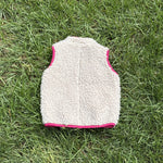 Pre-loved Patagonia cream retro-x fleece vest, kids size 12-18M, back view, laid flat on grass