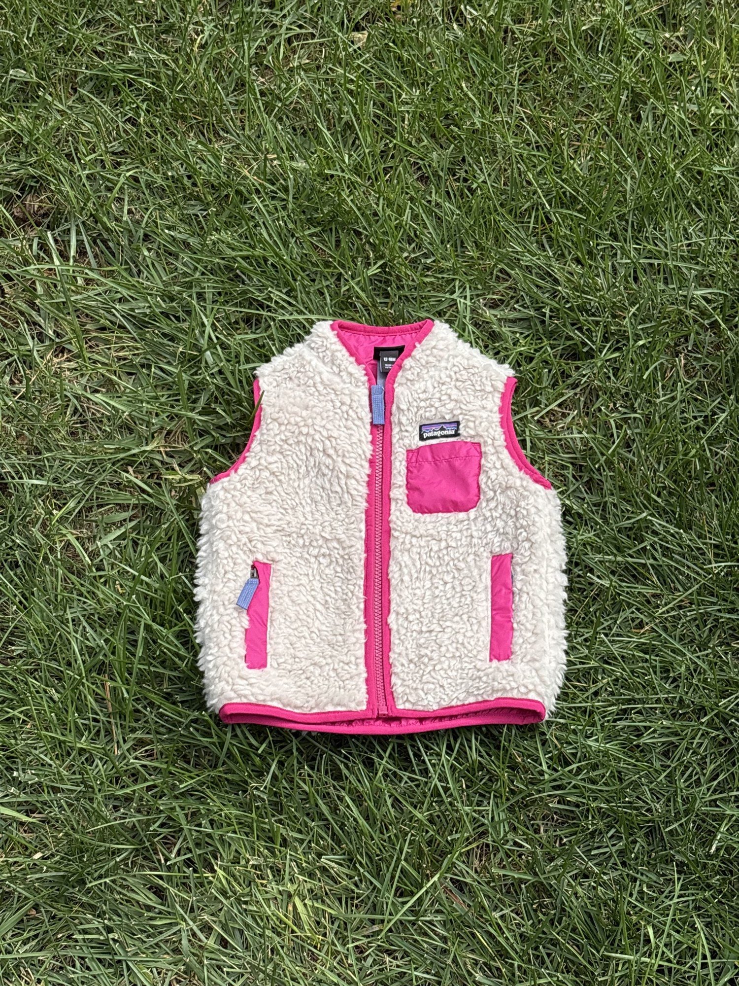 Pre-loved Patagonia cream retro-x fleece vest, kids size 12-18M, front view, laid flat on grass