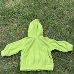Pre-loved Patagonia green hooded full-zip fleece jacket, kids size 6M, back view, laid flat on grass