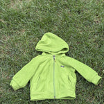 Pre-loved Patagonia green hooded full-zip fleece jacket, kids size 6M, front view, laid flat on grass