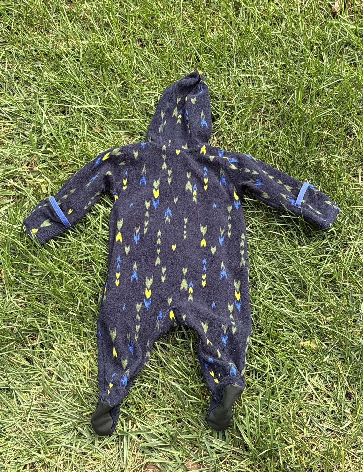 Pre-loved Patagonia navy arrow print fleece bunting, kids size 3-6M, back view, laid flat on grass