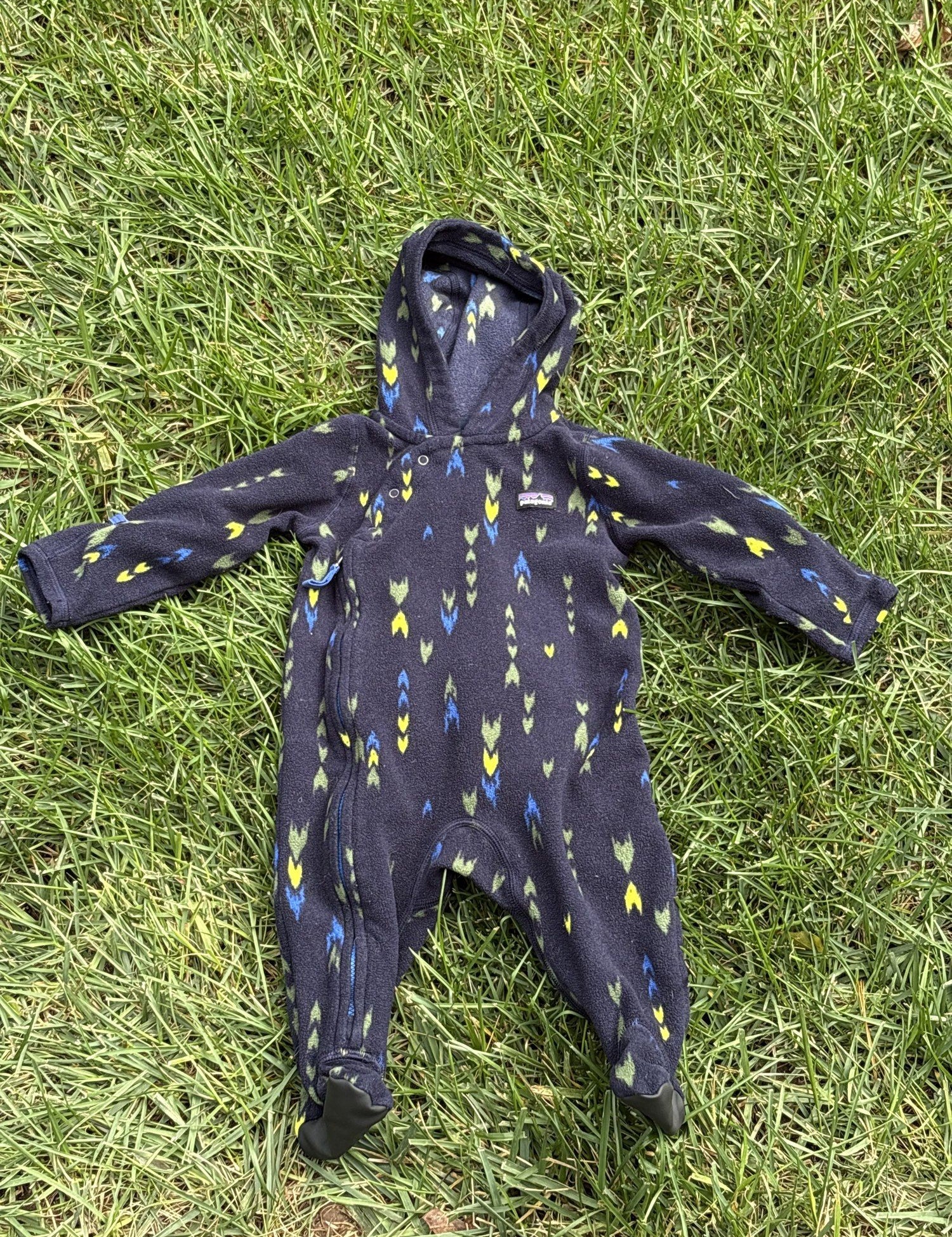 Pre-loved Patagonia navy arrow print fleece bunting, kids size 3-6M, front view, laid flat on grass