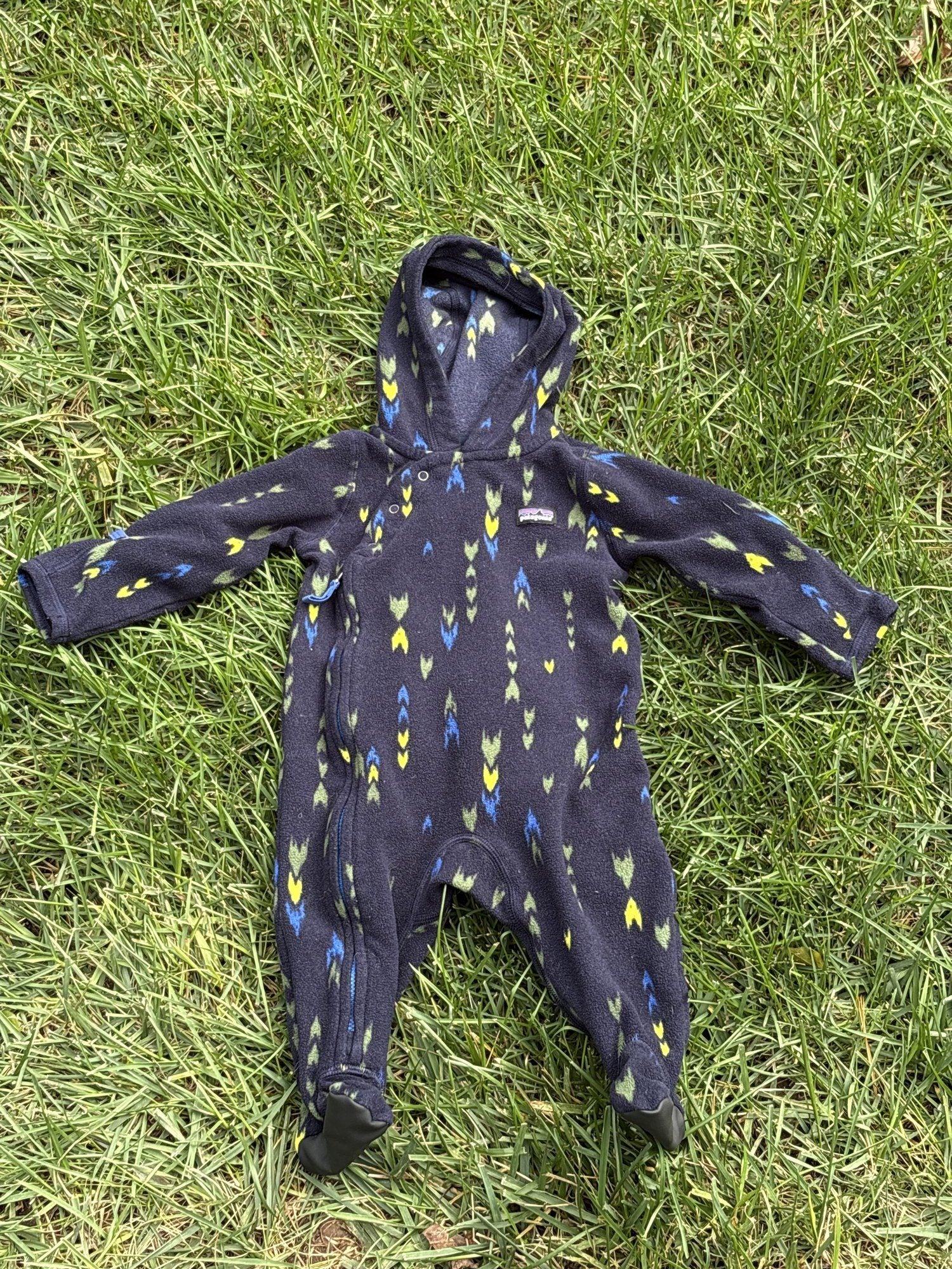 Pre-loved Patagonia navy arrow print fleece bunting, kids size 3-6M, front view, laid flat on grass
