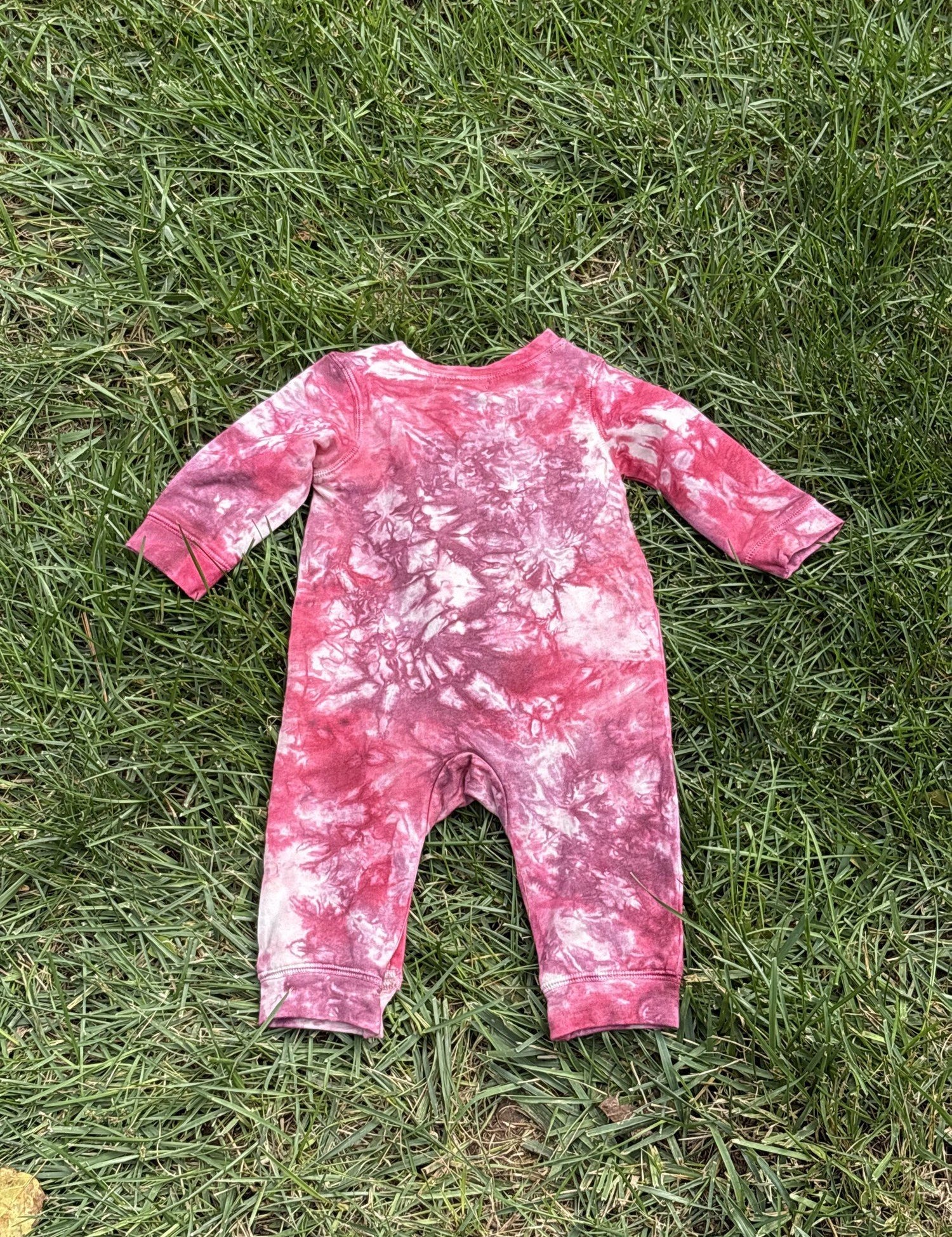 Pre-loved Red Egg & Ginger pink tie-dye gold star romper, kids size 3-6M, back view, laid flat on grass