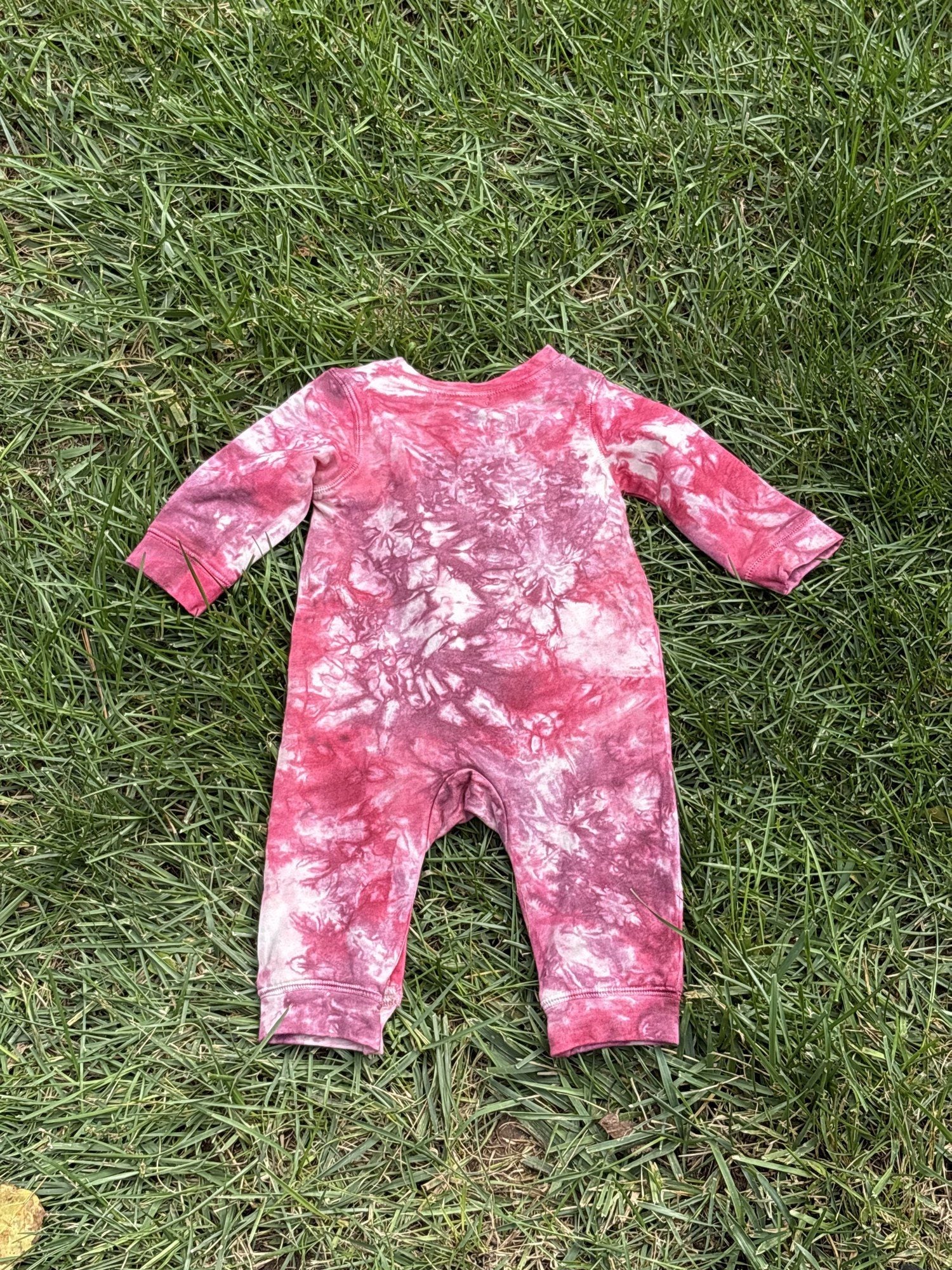 Pre-loved Red Egg & Ginger pink tie-dye gold star romper, kids size 3-6M, back view, laid flat on grass