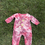 Pre-loved Red Egg & Ginger pink tie-dye gold star romper, kids size 3-6M, front view, laid flat on grass