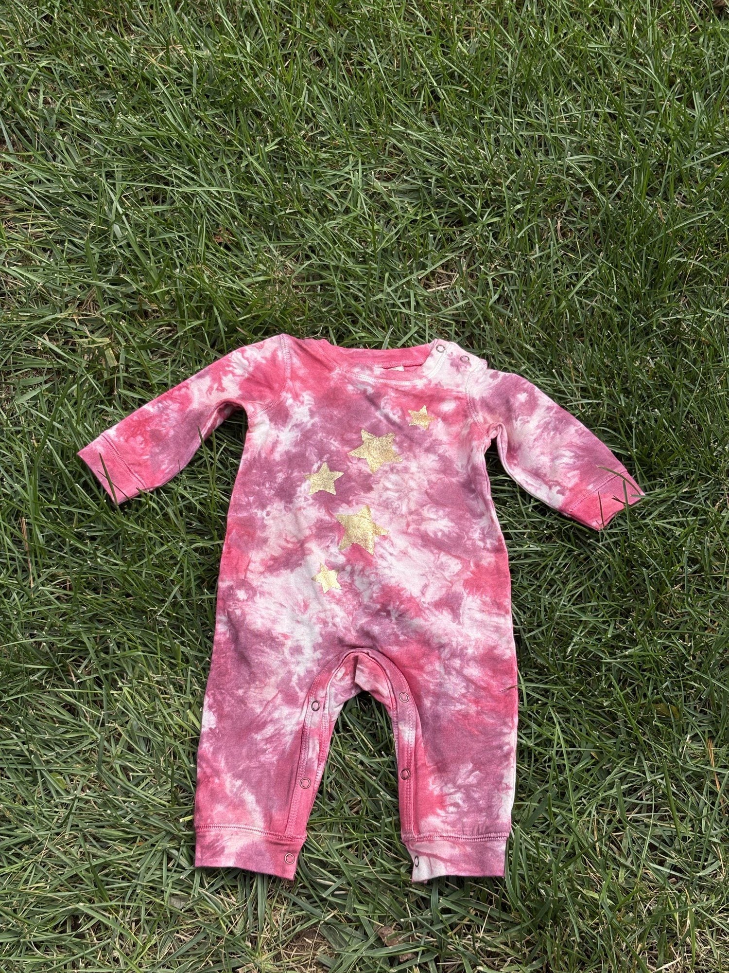 Pre-loved Red Egg & Ginger pink tie-dye gold star romper, kids size 3-6M, front view, laid flat on grass