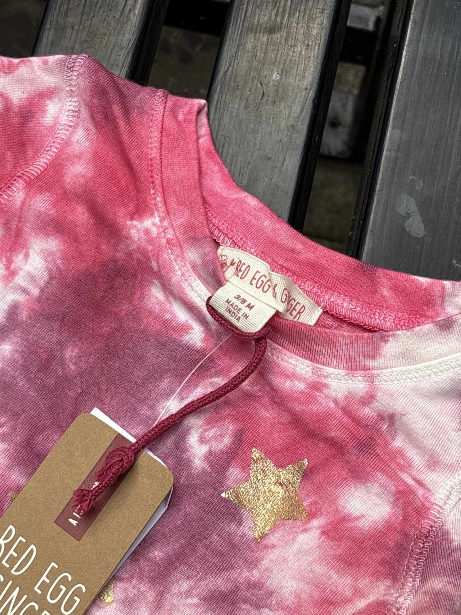 Pre-loved Red Egg & Ginger pink tie-dye gold star romper, kids size 3-6M, brand and size label close-up