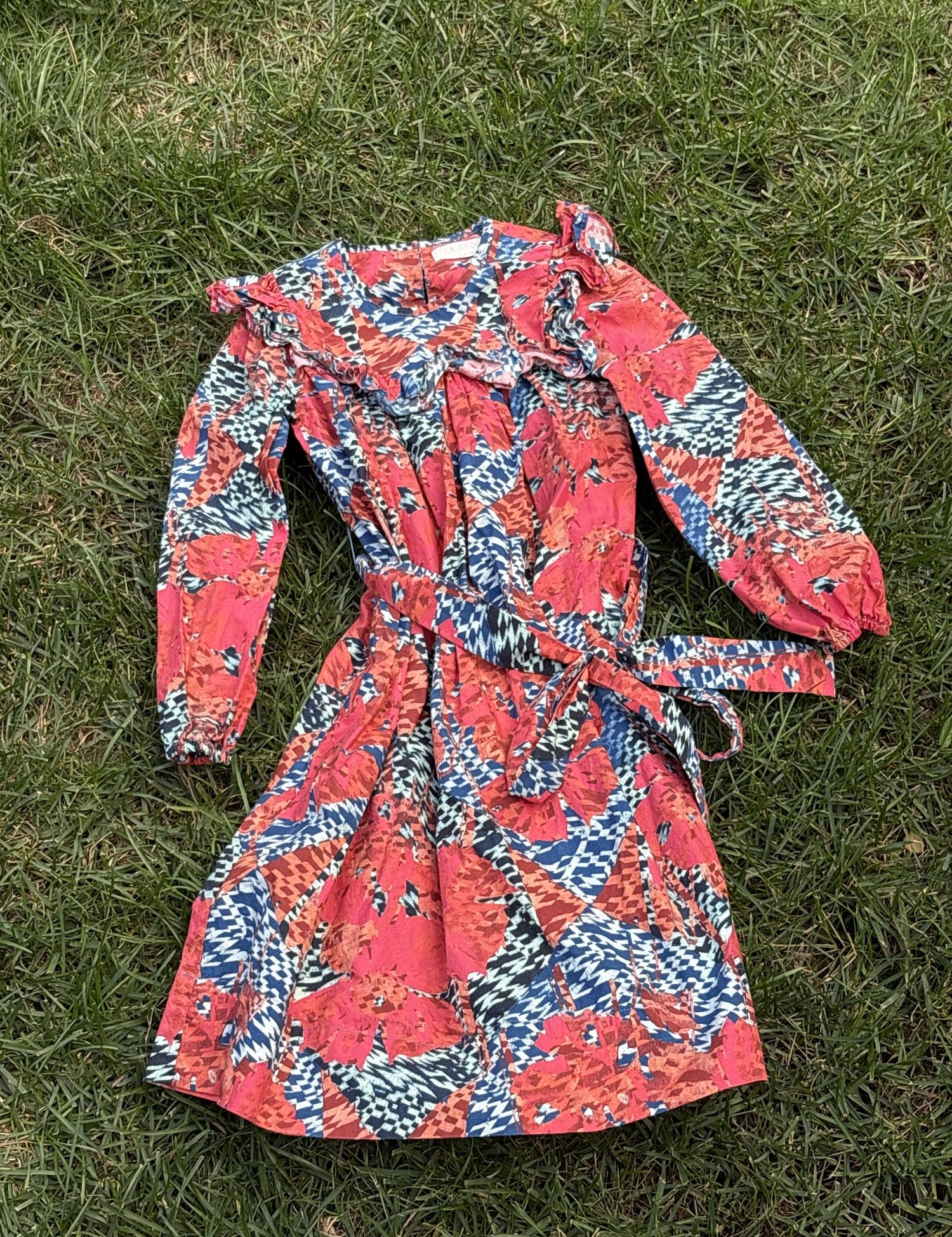 Pre-loved Ulla Johnson coral and blue botanical print dress, kids size 6, front view, laid flat on grass